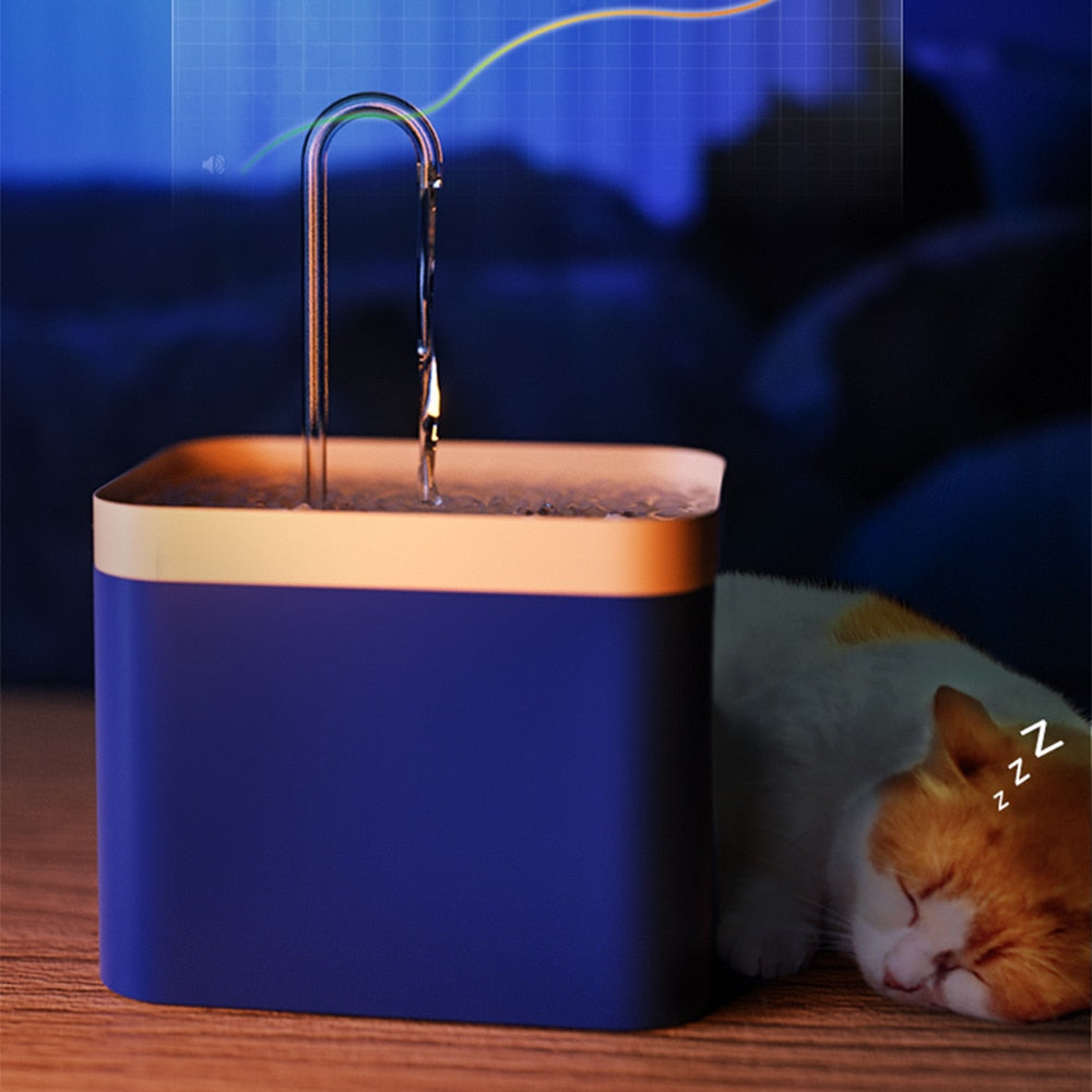 Trinkbrunnen für Katzen in  der Farbe Blau mit daneben liegender Katze schlafend.
